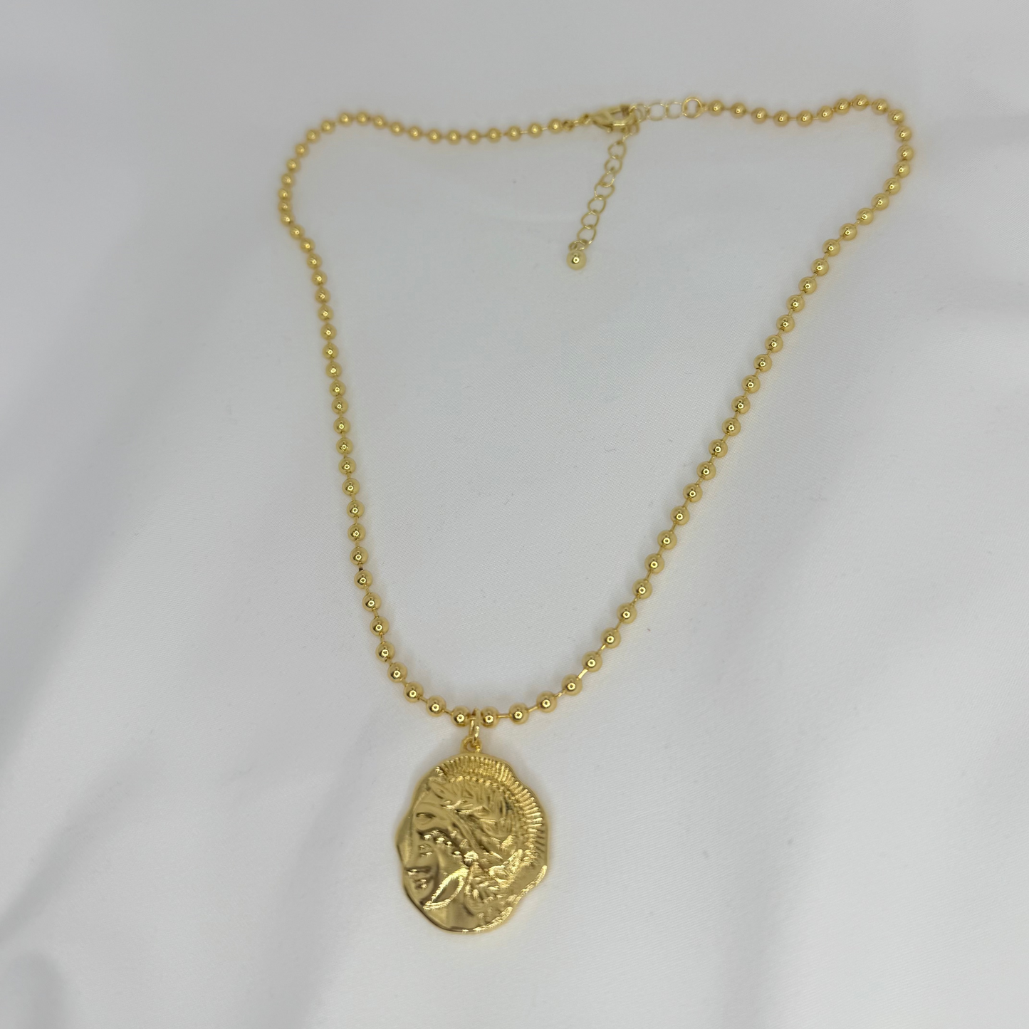 Gold necklace with a pendant on a white background