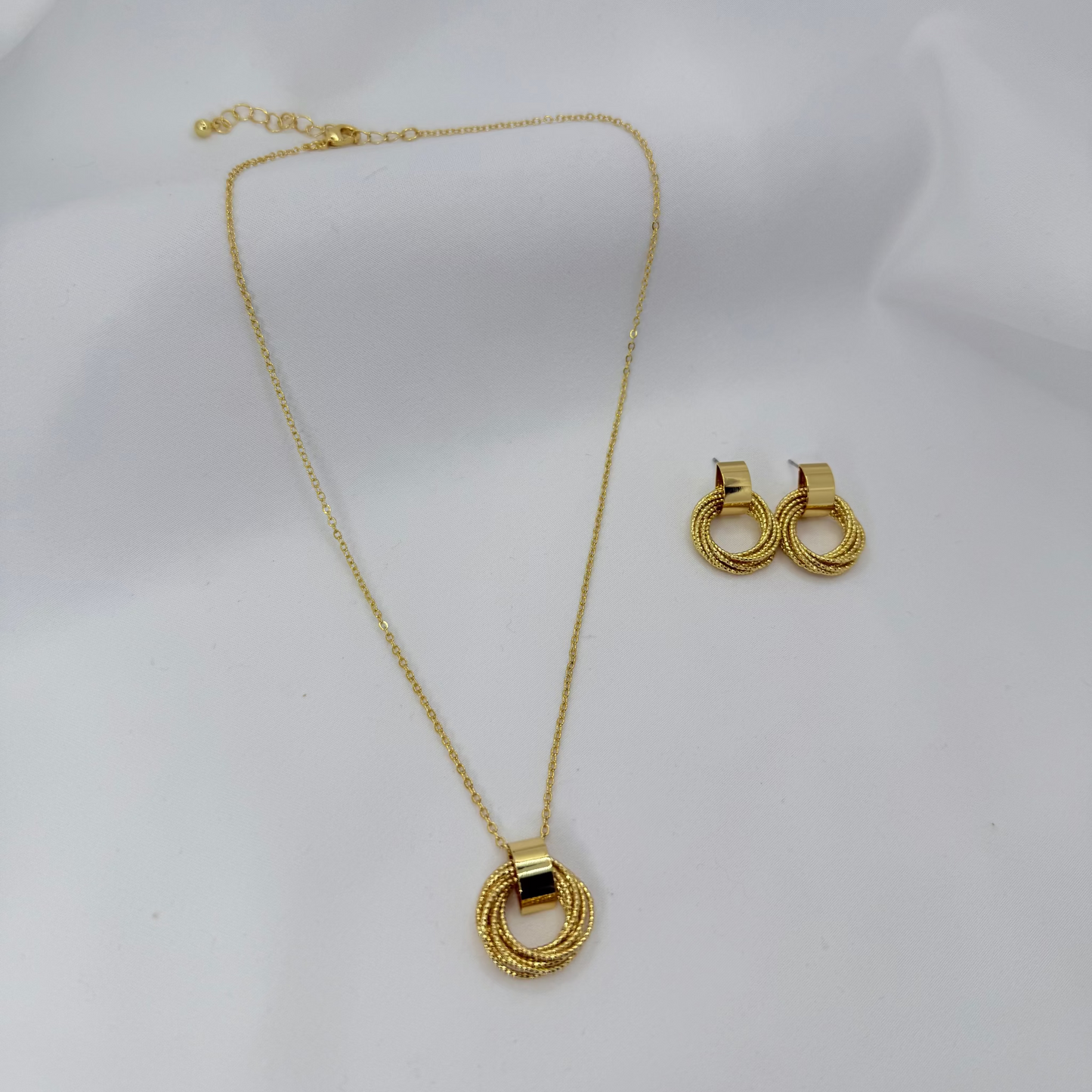 Gold necklace and earrings on a white mannequin bust