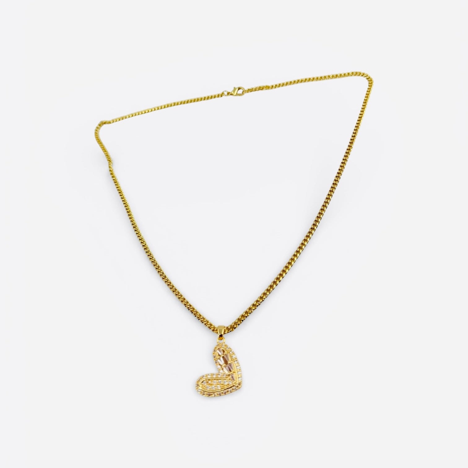 Gold necklace with a heart-shaped pendant on a white background