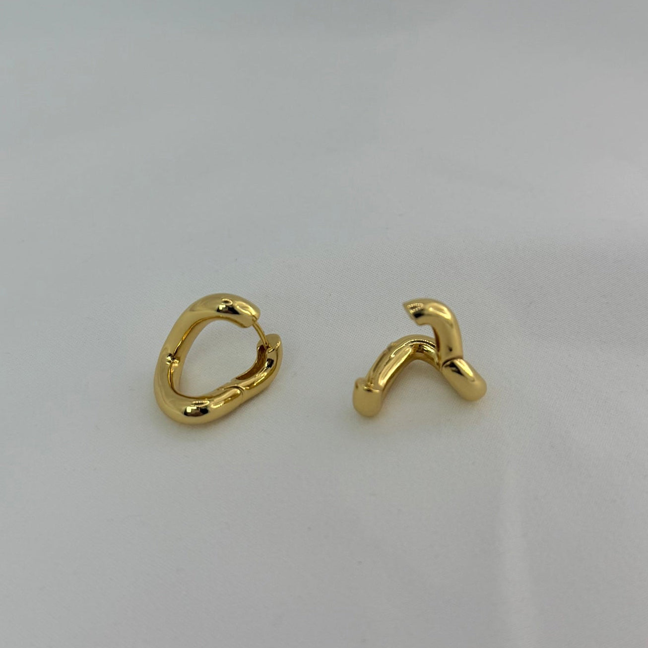 Pair of gold hoop earrings on a light gray background
