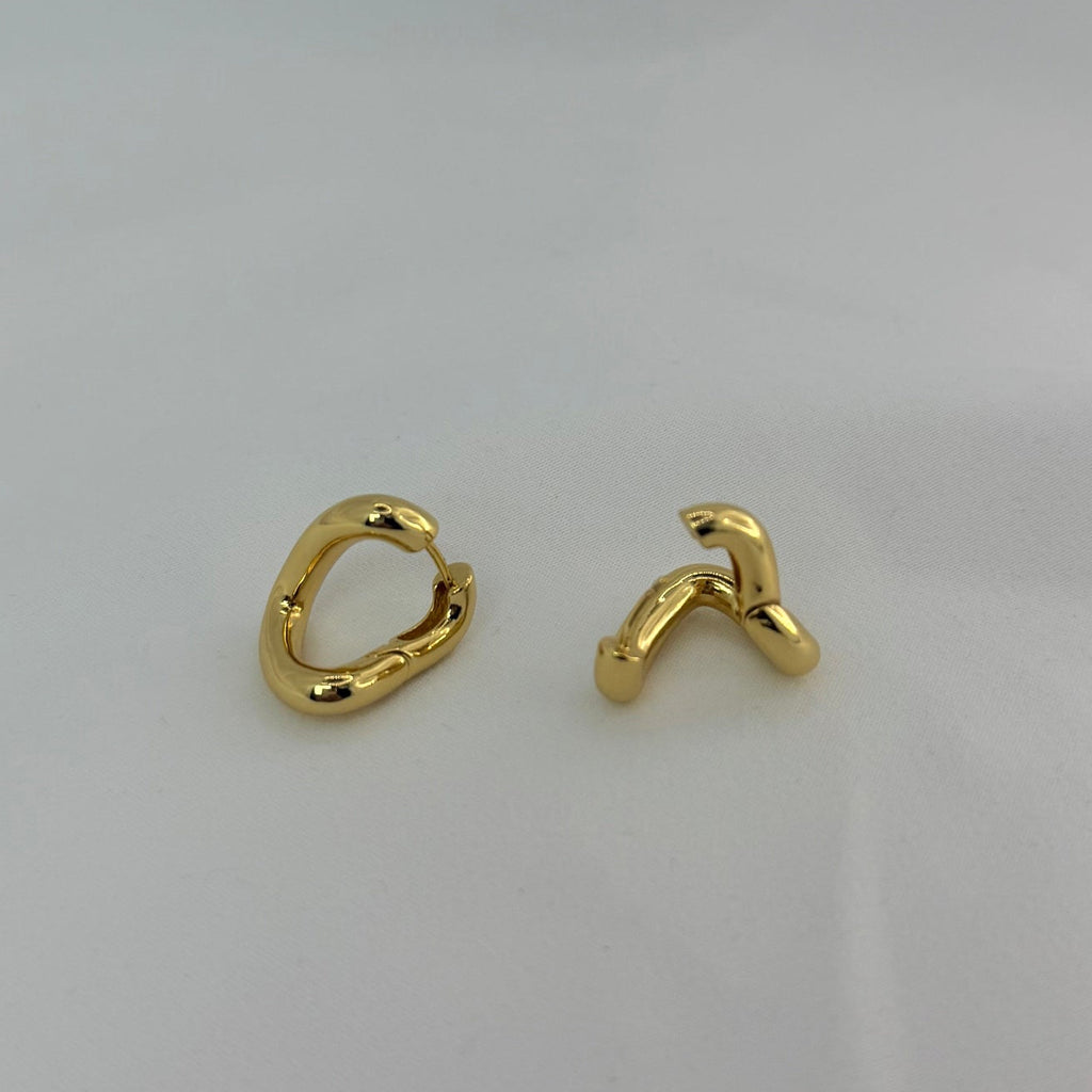 Pair of gold hoop earrings on a light gray background
