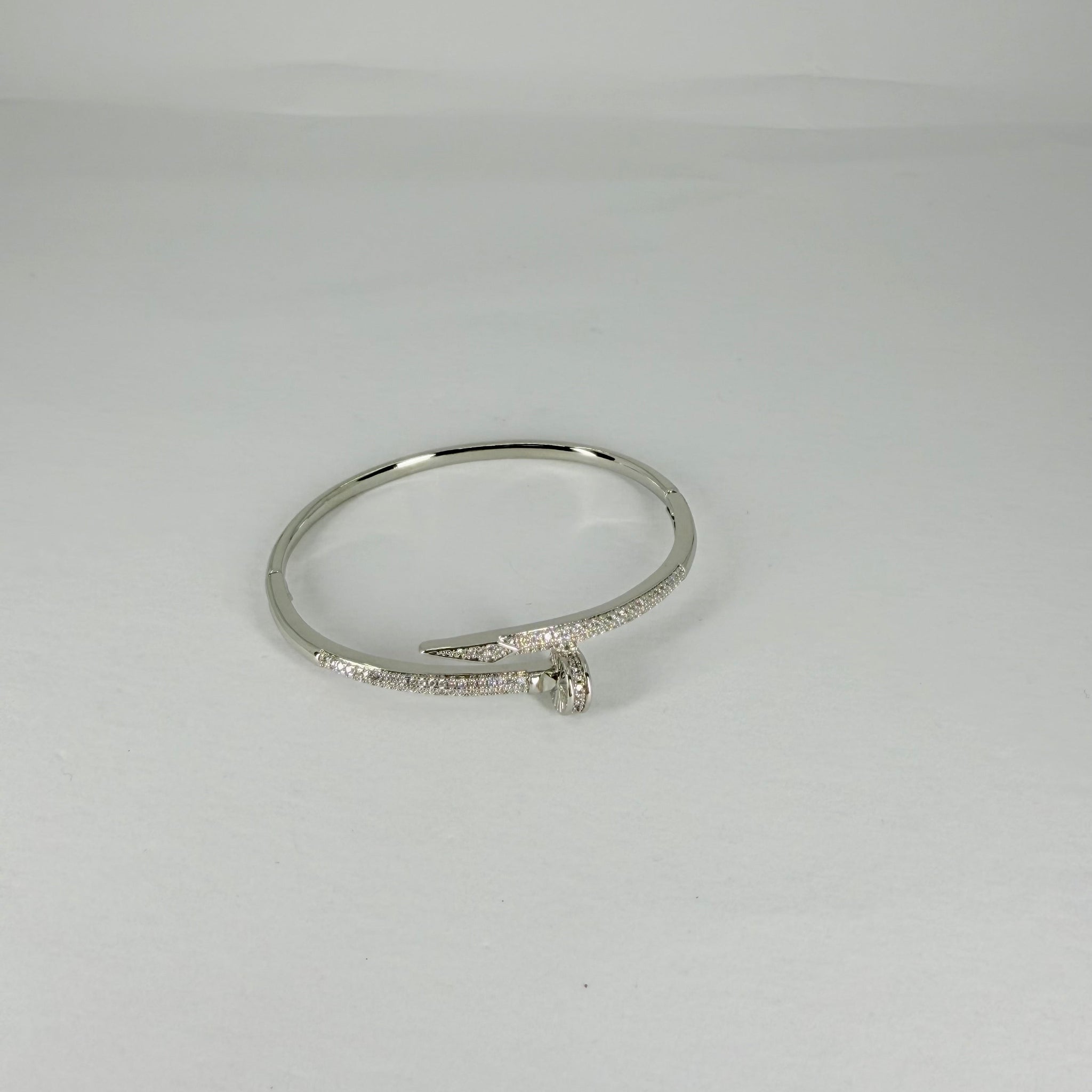 Silver bracelet with a small diamond on a light gray background