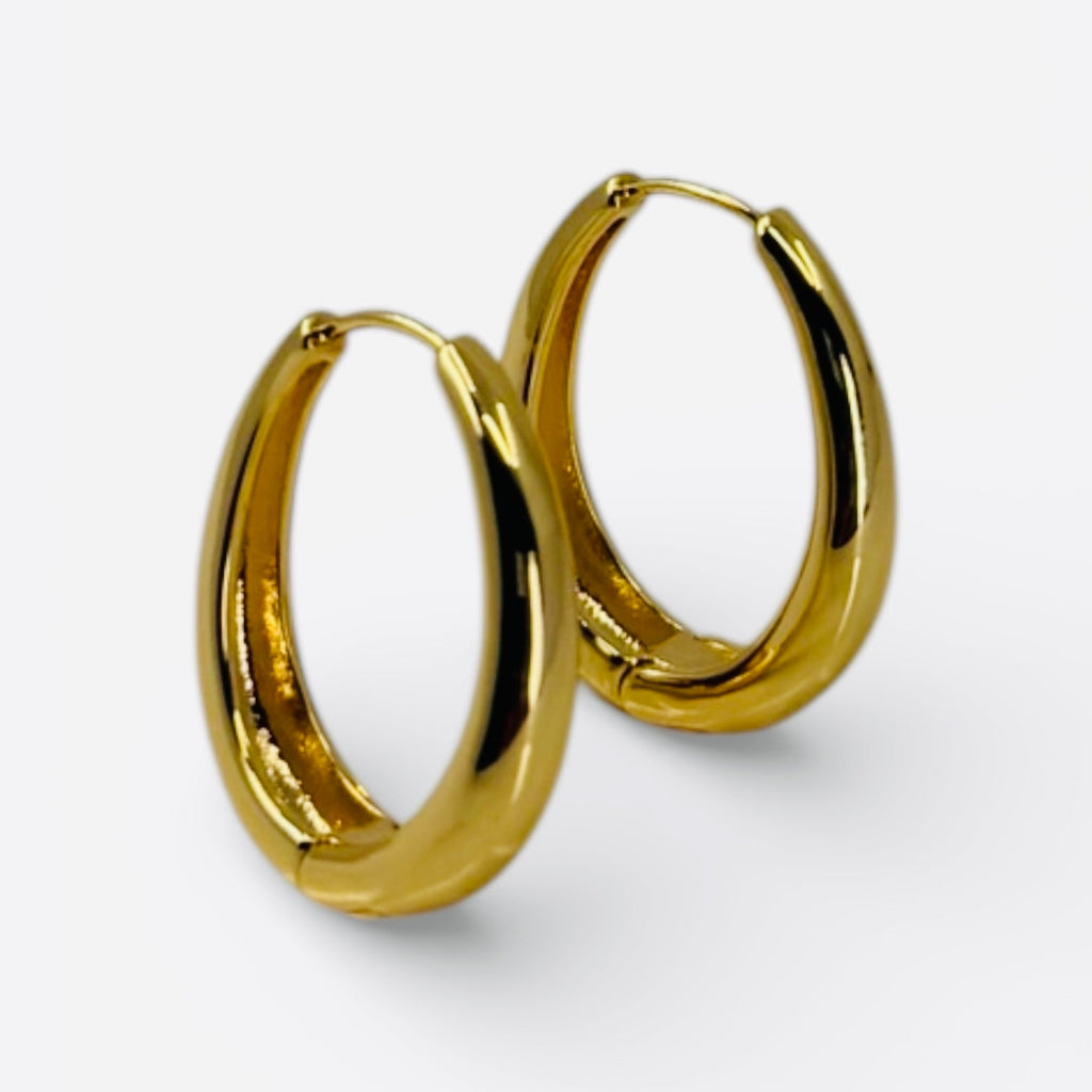 18K gold plated over brass, these polished oval hoop earrings feature a sleek, refined design with a smooth, high-shine finish.

