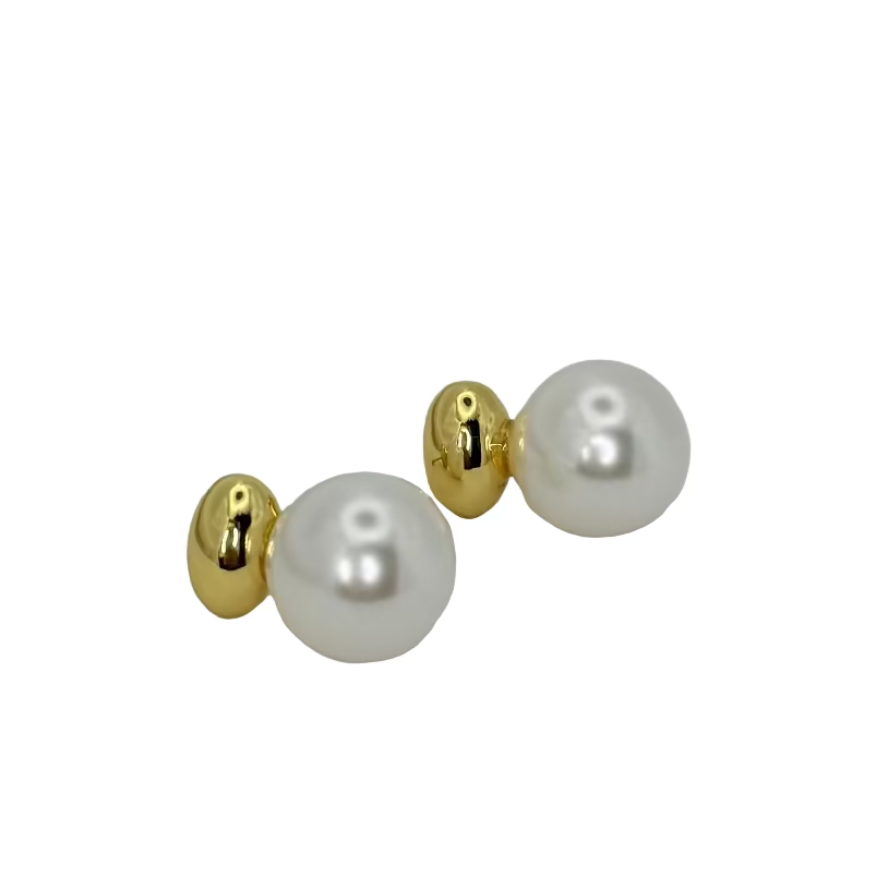 Pair of pearl earrings with gold accents on a light gray background