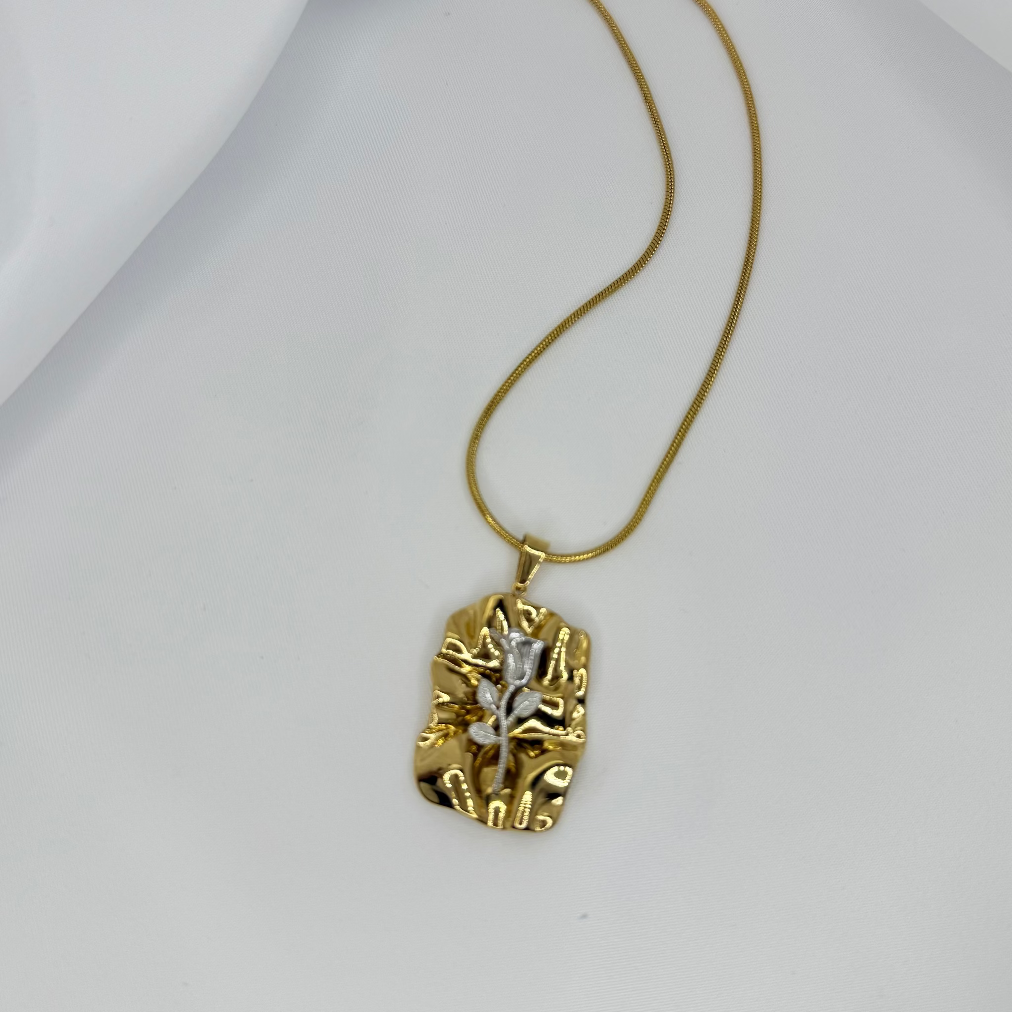 Gold necklace with a unique pendant on a white background