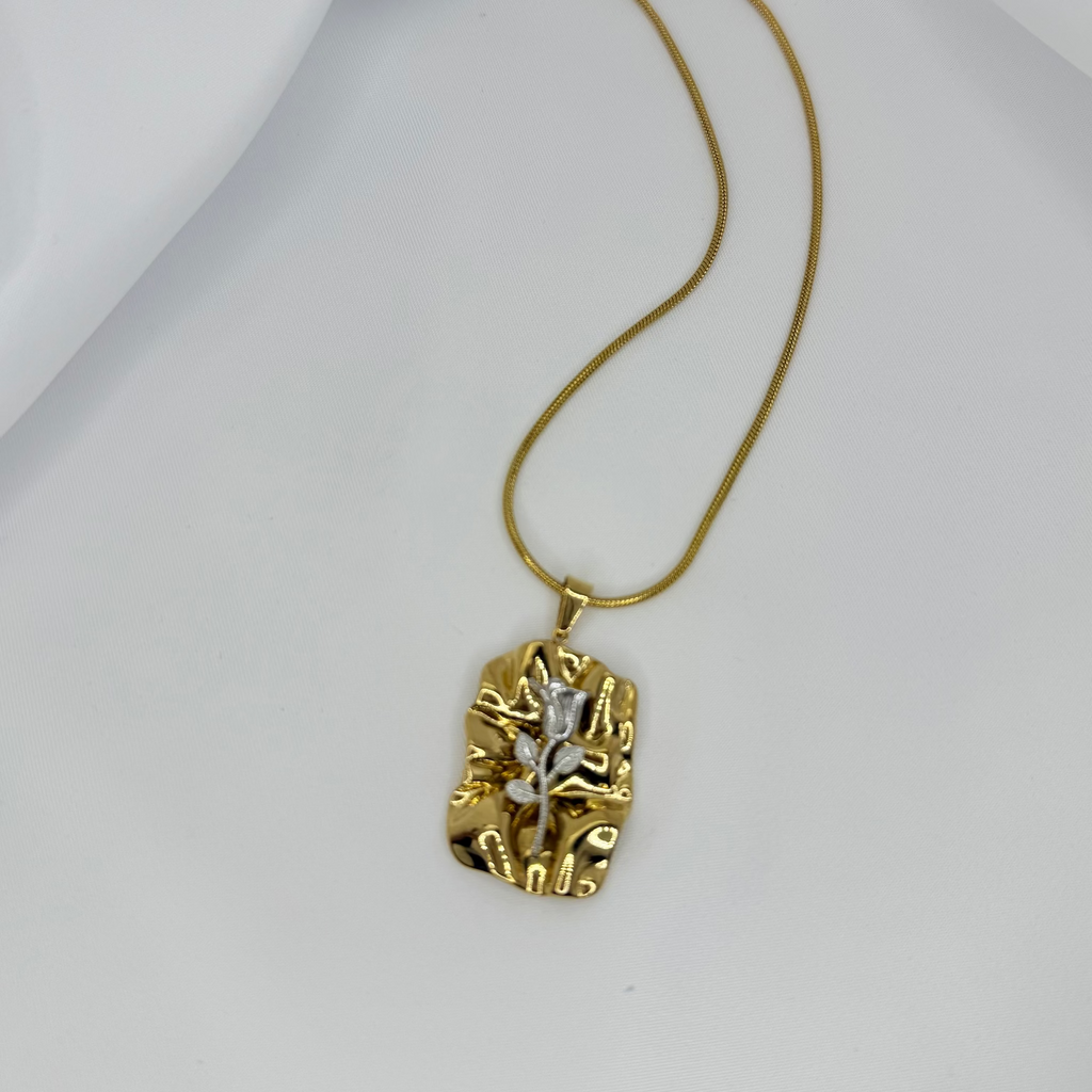 Gold necklace with a unique pendant on a white background