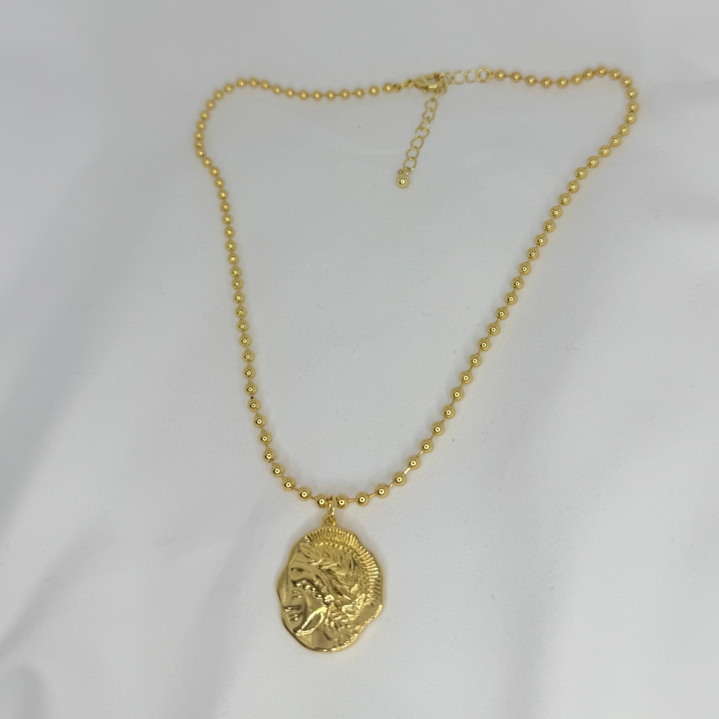 Gold necklace with a pendant on a white background