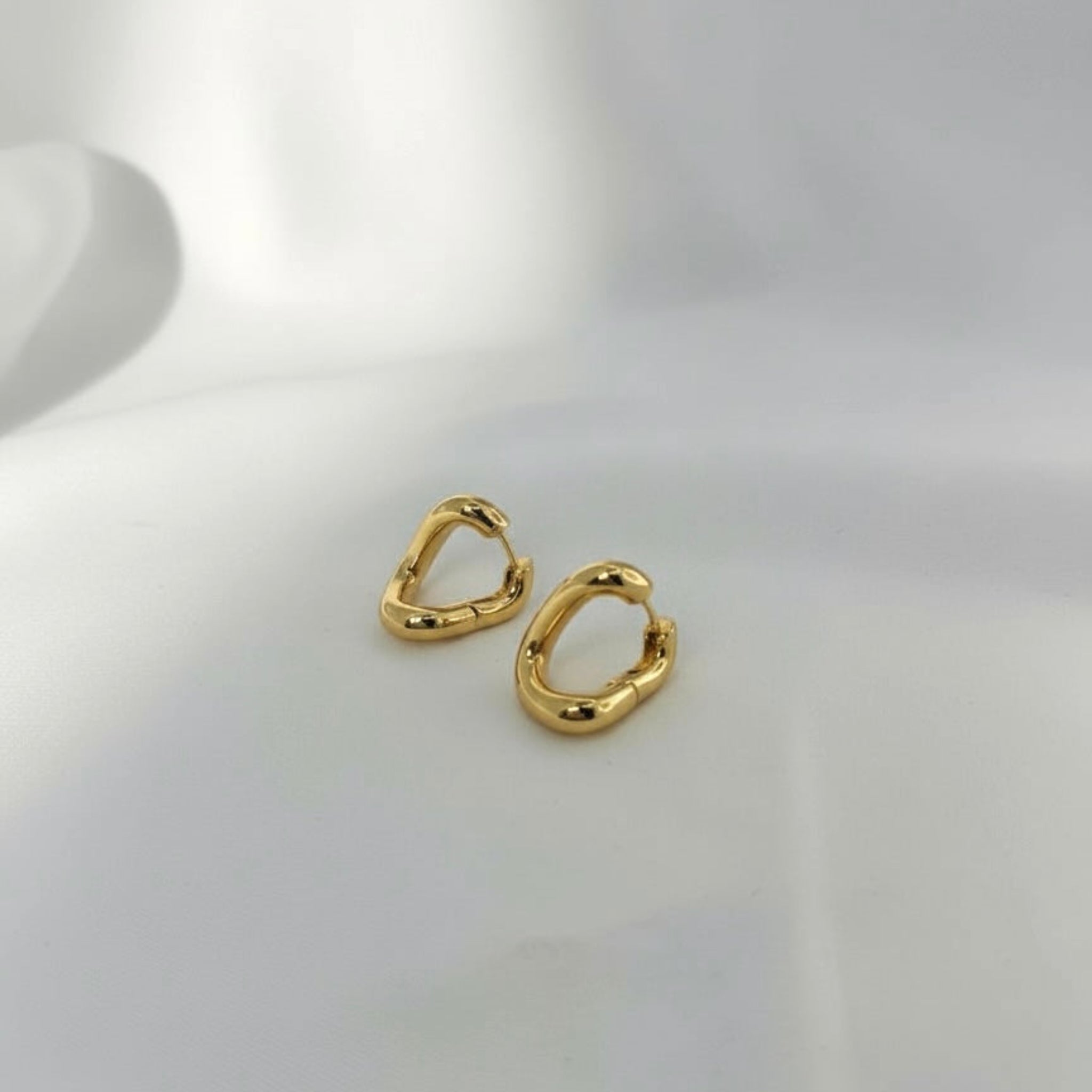 Gold hoop earrings on a light gray background