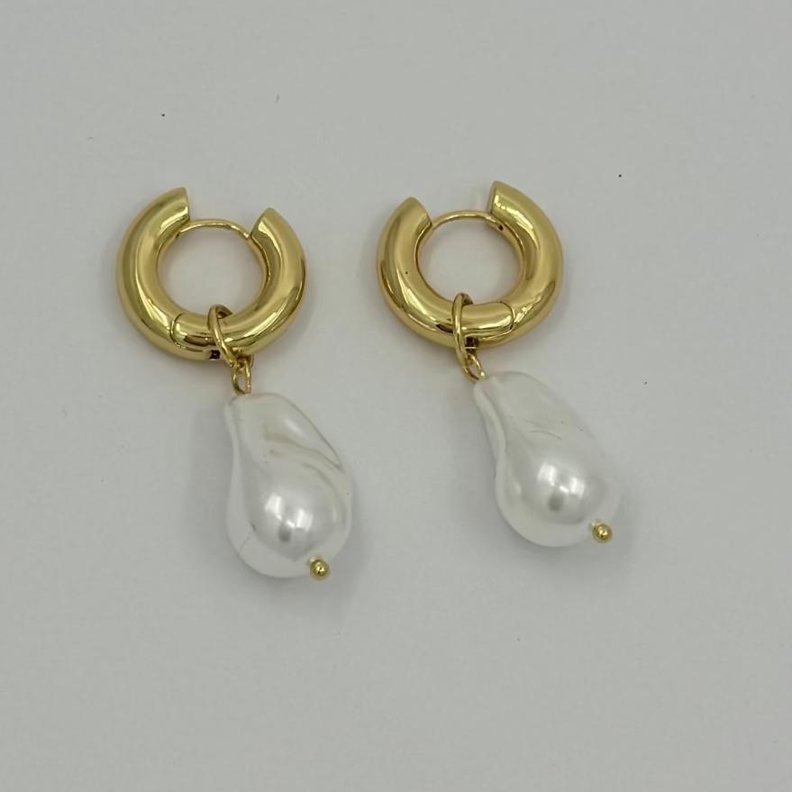 Pair of gold and pearl teardrop earrings on a light gray background