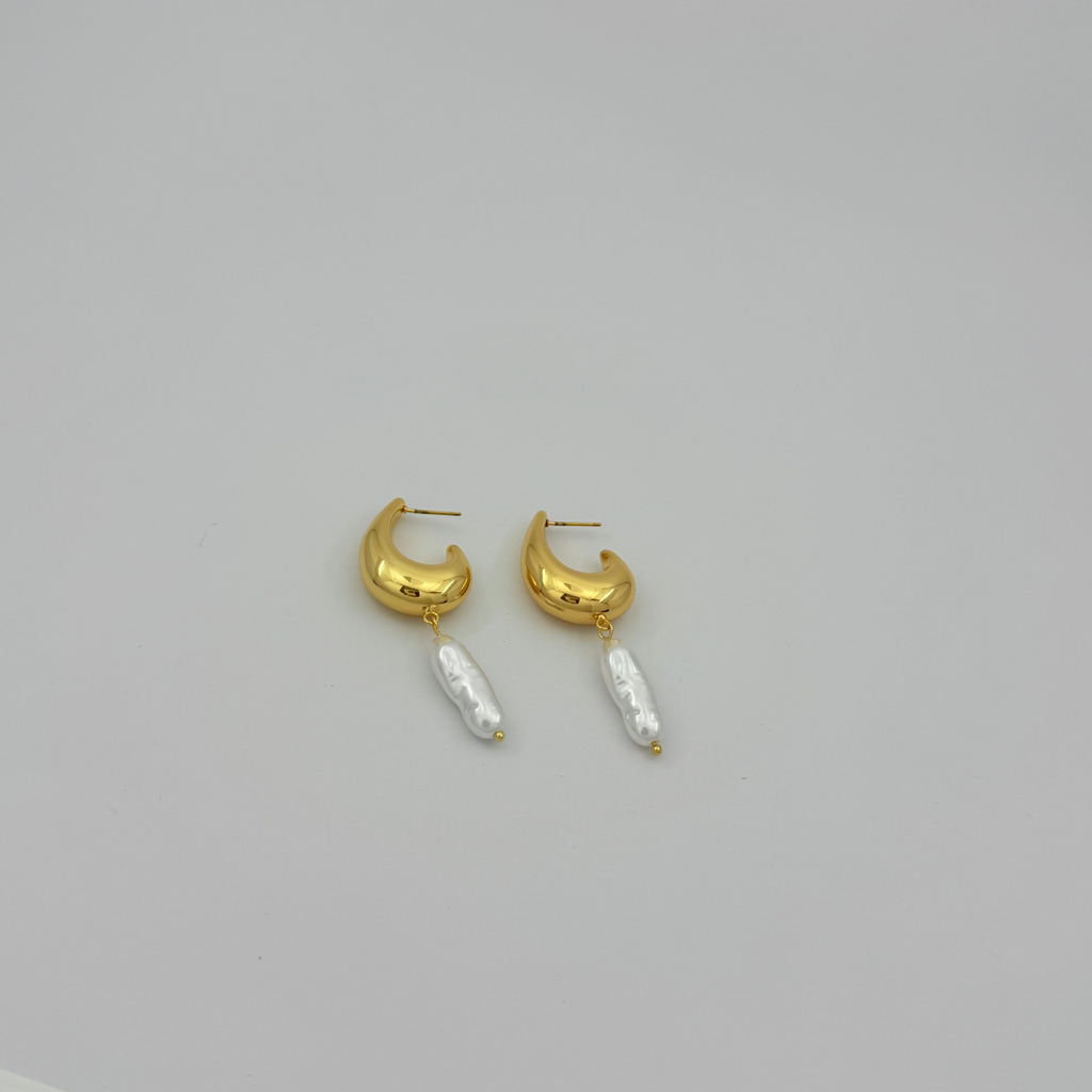 Gold hoop earrings with pearl-like beads on a light gray background