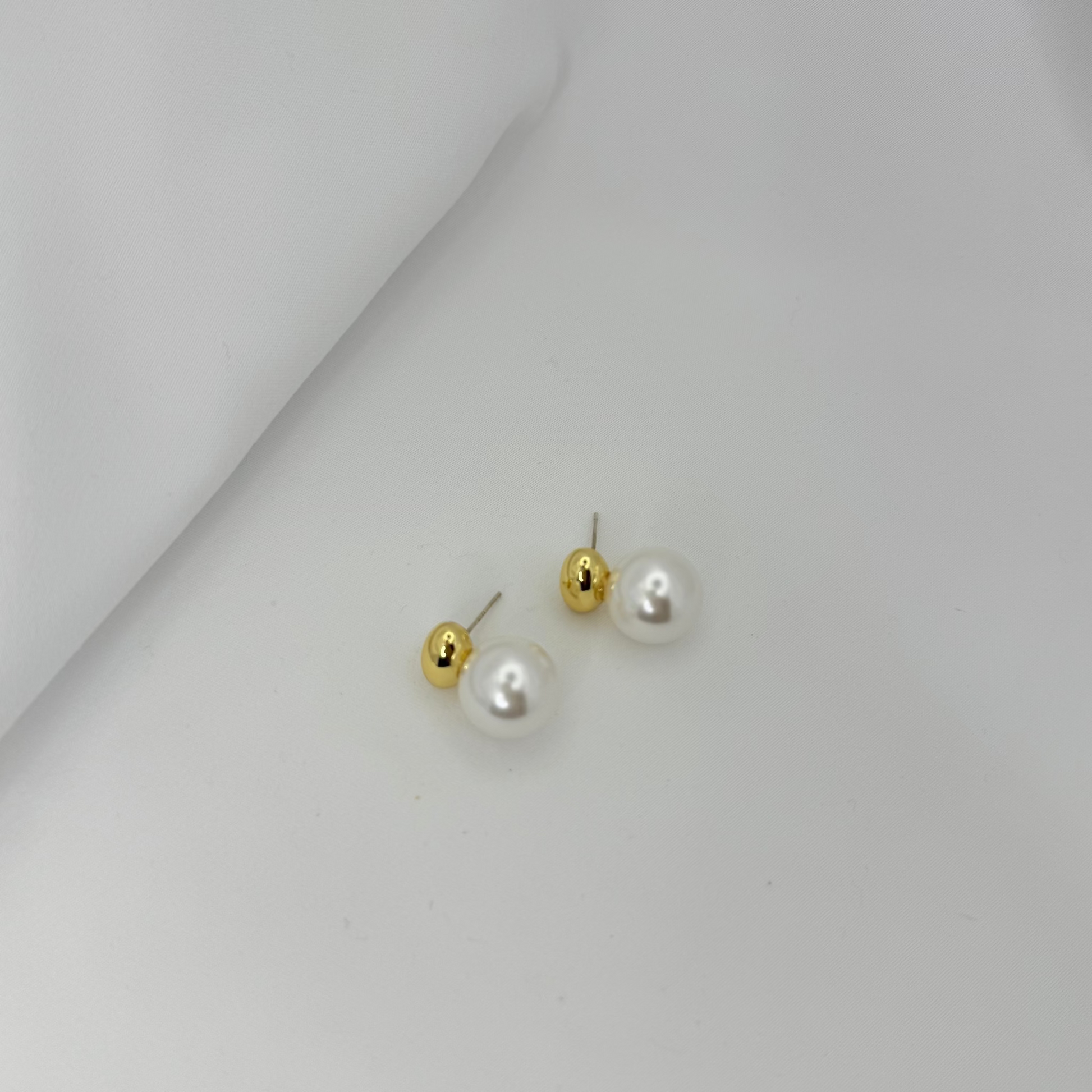 Pair of pearl earrings on a light gray background