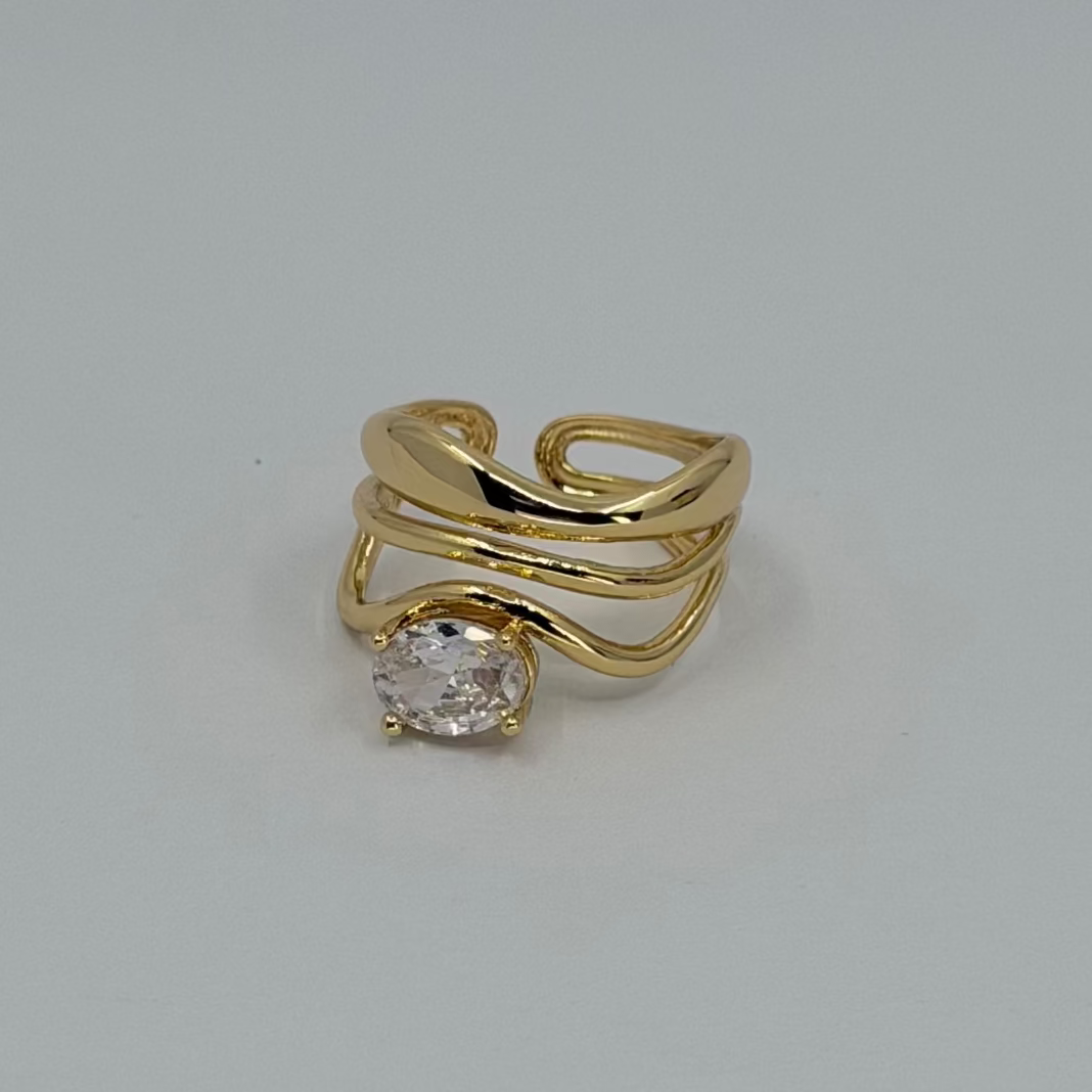 Gold ring with a clear gemstone on a light gray background