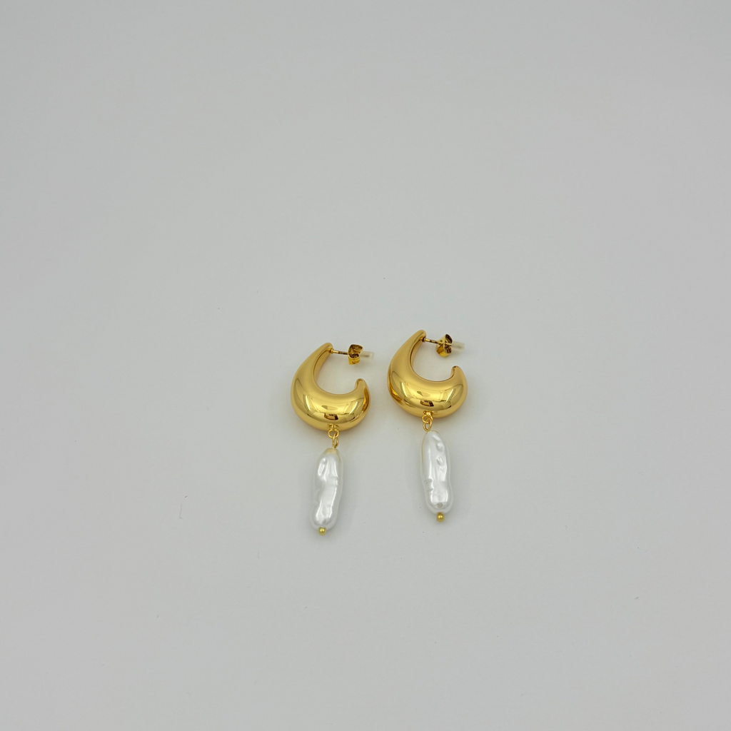 Gold hoop earrings with pearl-like beads on a light gray background