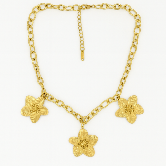 Gold chain necklace with floral pendants on a white background