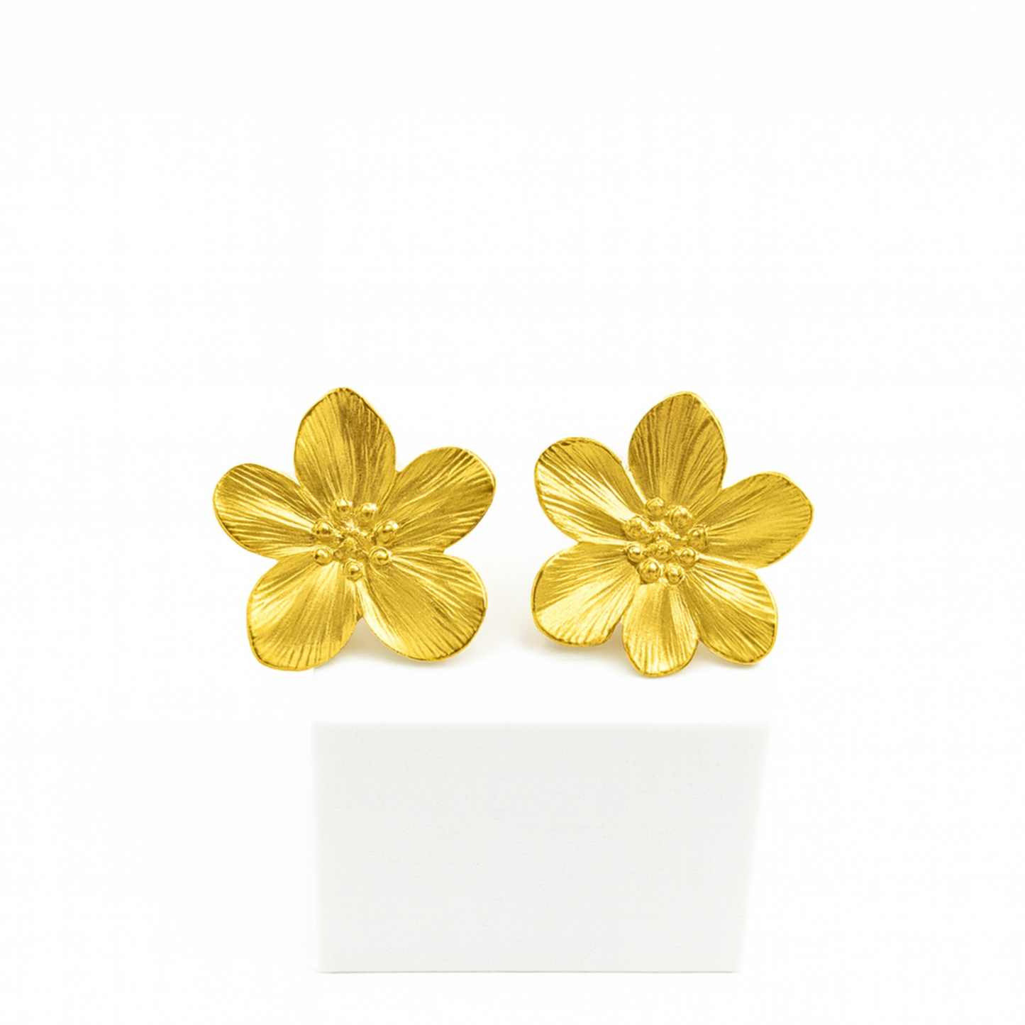 Gold flower-shaped earrings on a white background