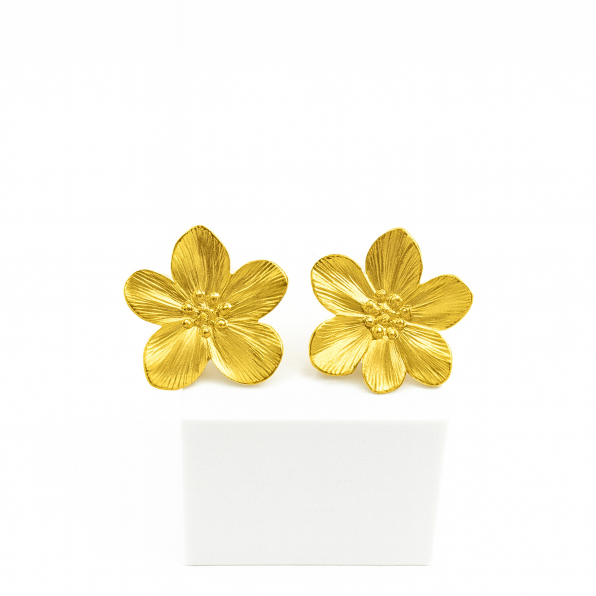 Gold flower-shaped earrings on a white background