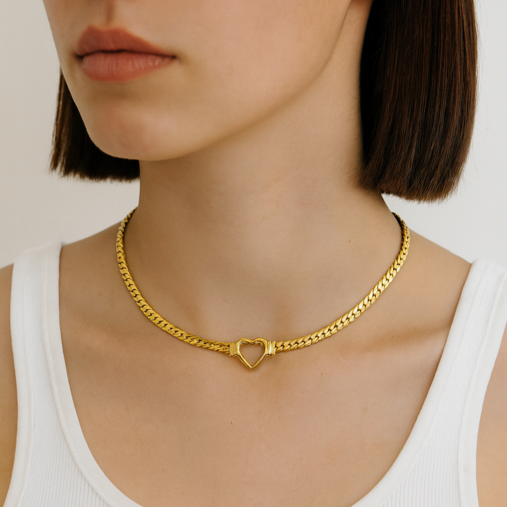 Woman wearing a gold necklace with a heart pendant, branded 'Chello Jewelry'.