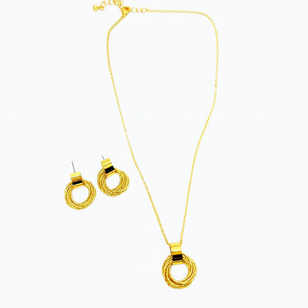 Gold necklace and earrings set on a white background