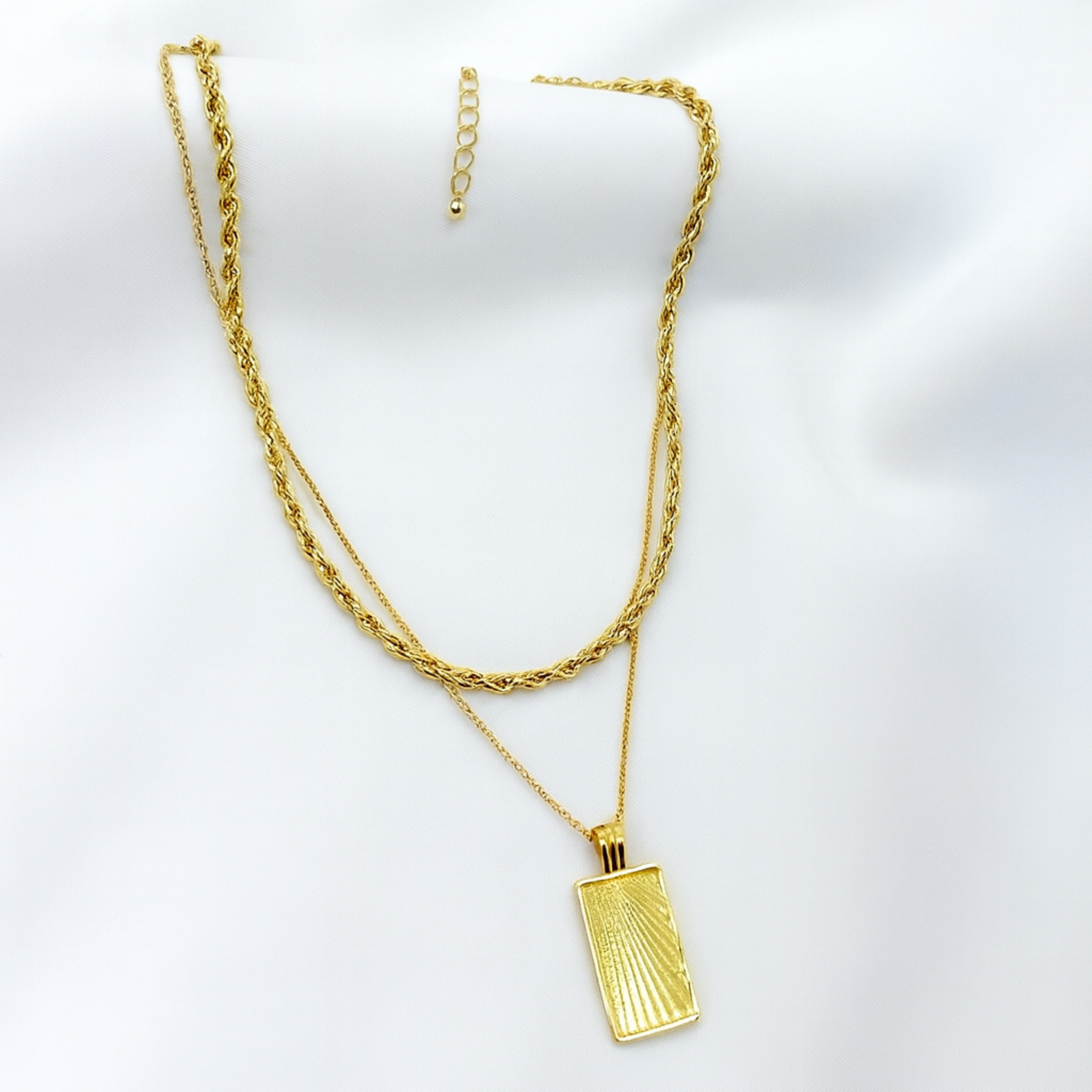 Gold necklace with a pendant on a white background