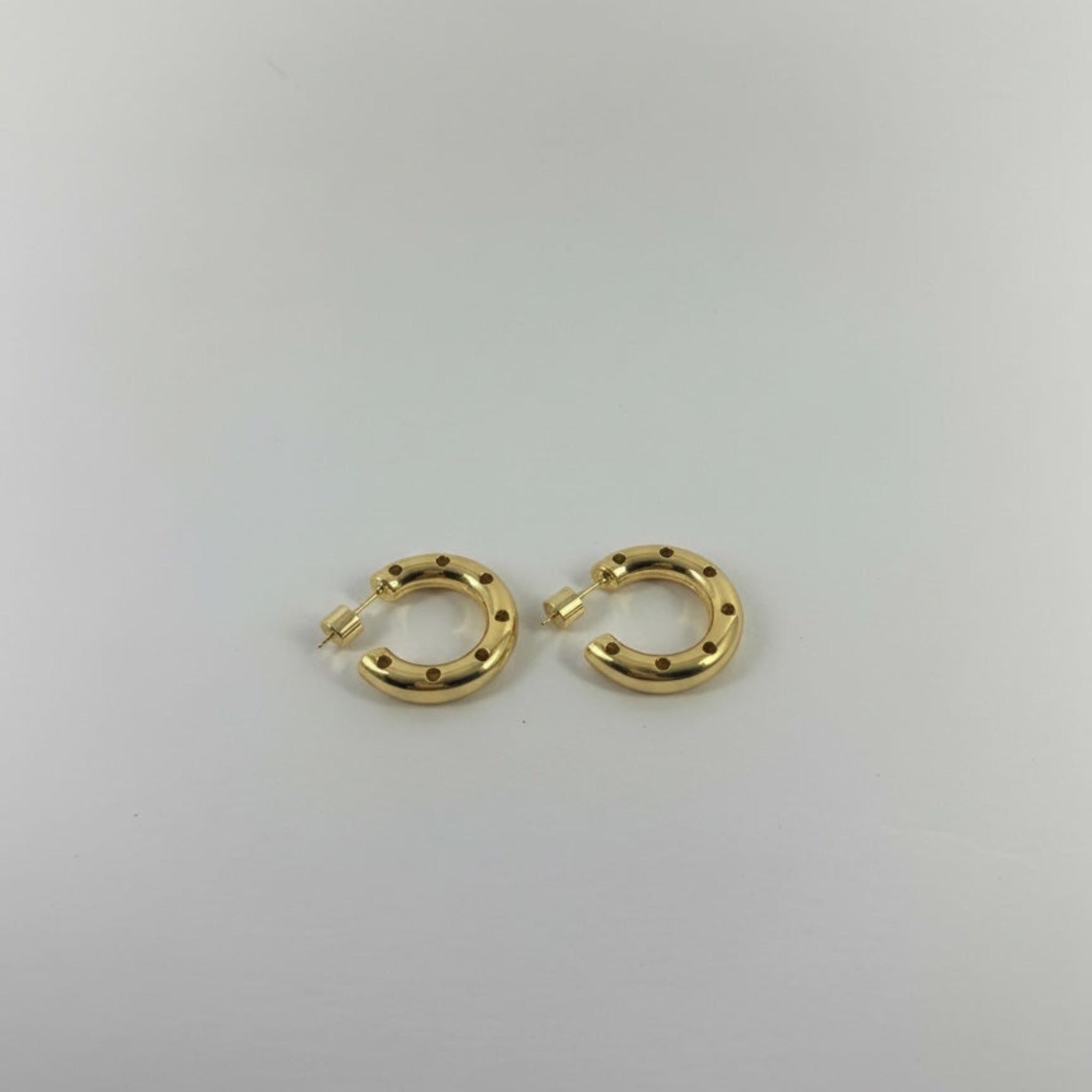 Gold hoop earrings on a light gray background