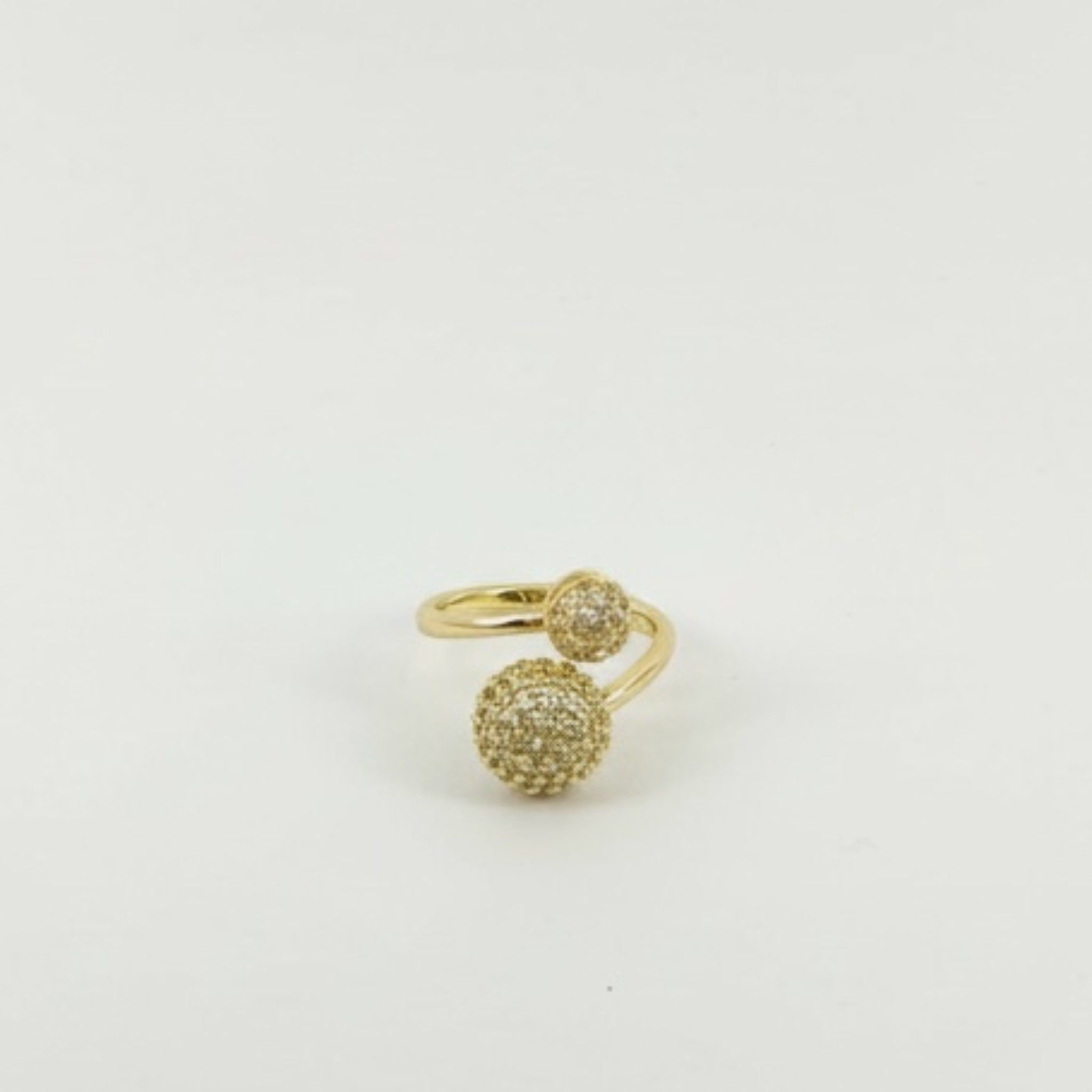 Gold ring with a textured ball design on a light gray background