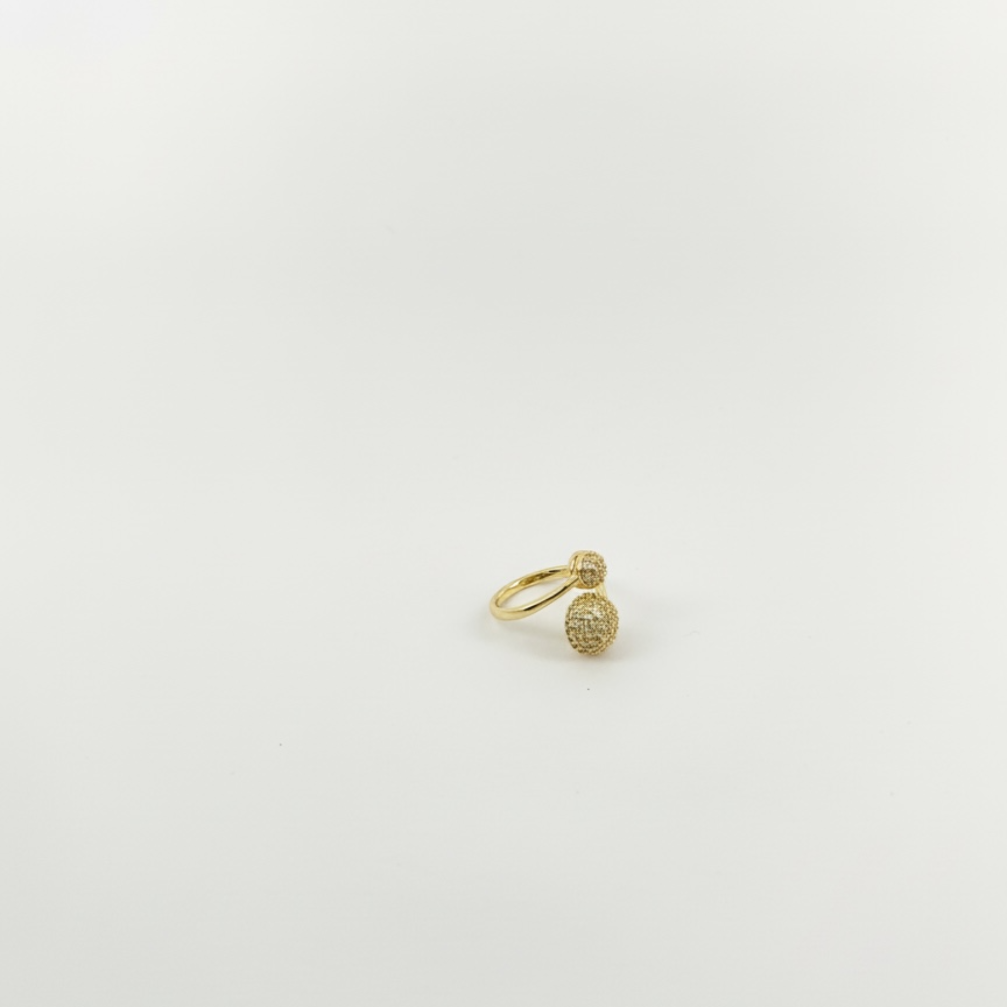 Gold ring with small stones on a light gray background