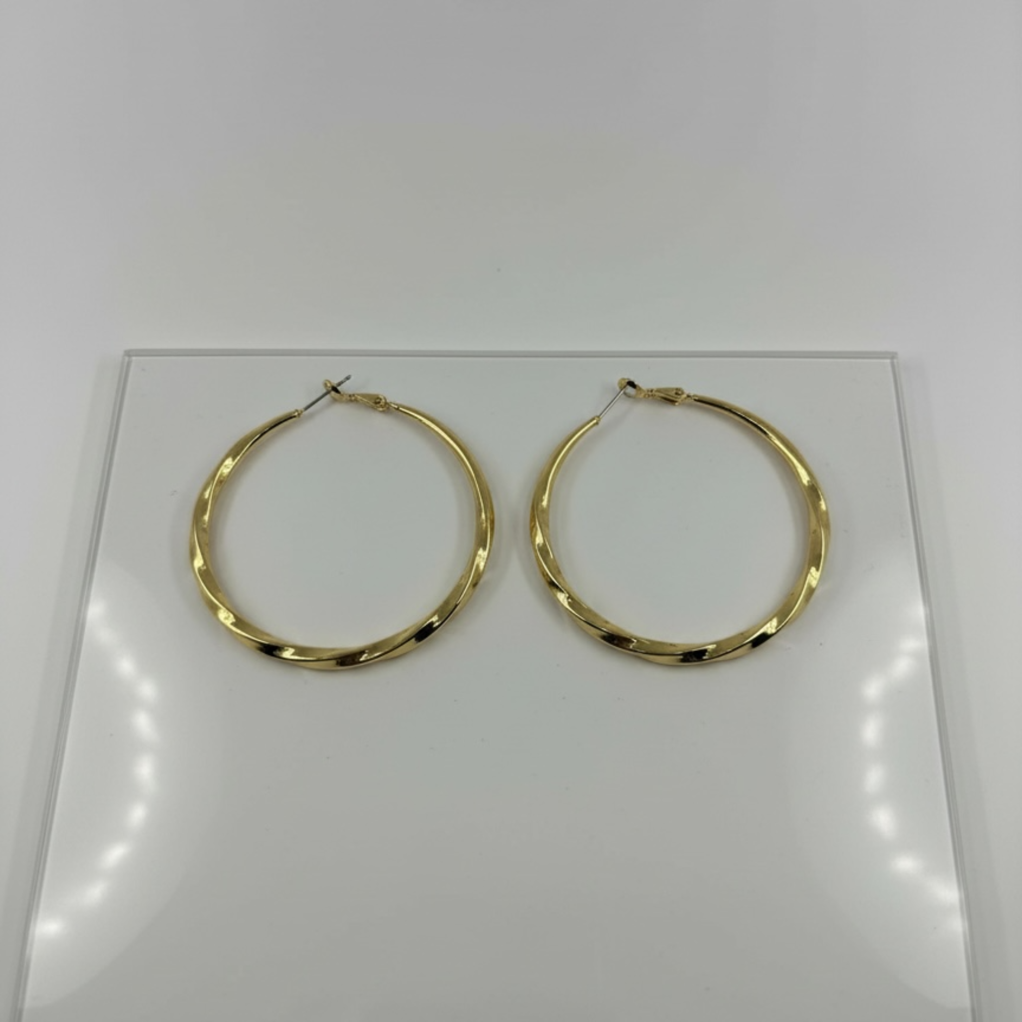 Gold hoop earrings on a white card