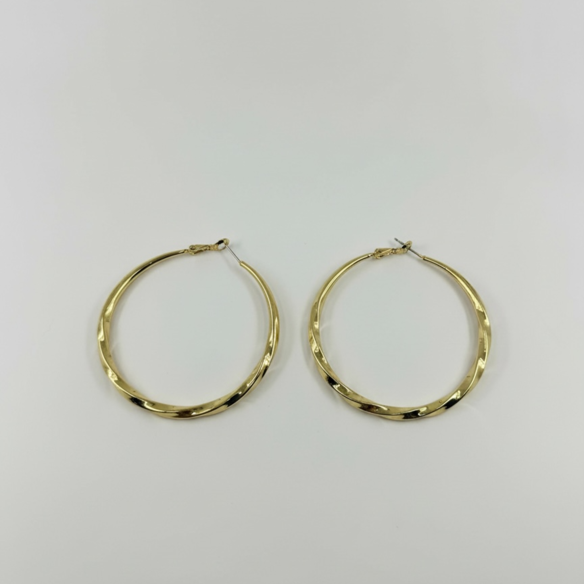 Gold hoop earrings on a light gray background