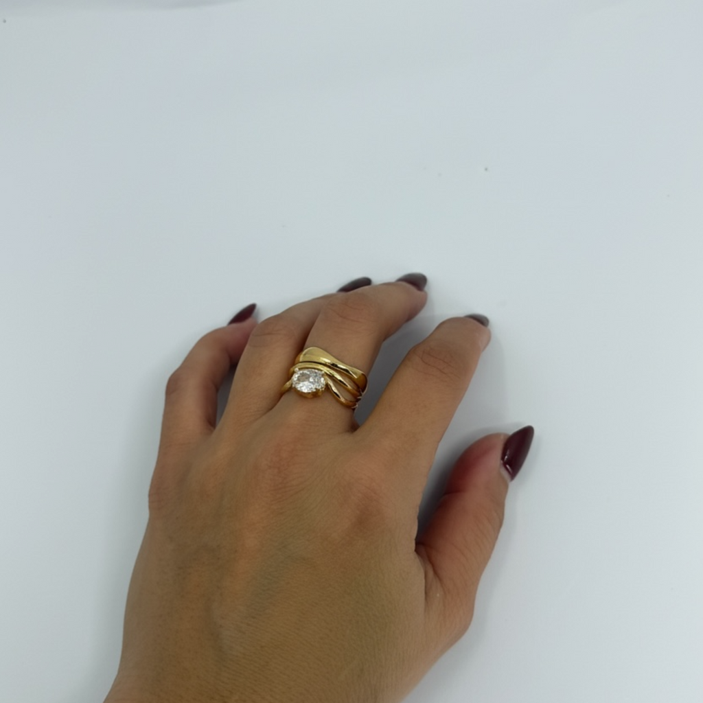 Hand wearing a gold ring on a white background