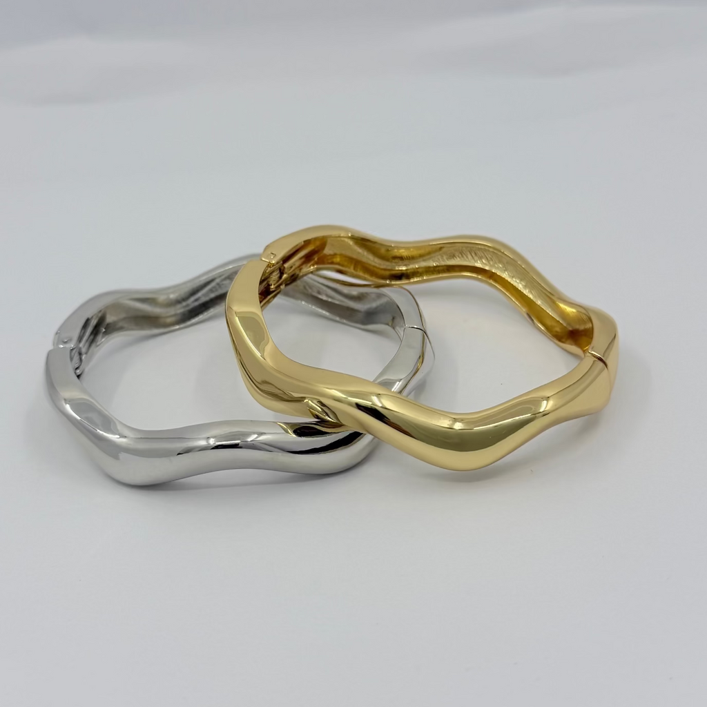 Two rings, one gold and one silver, on a white background