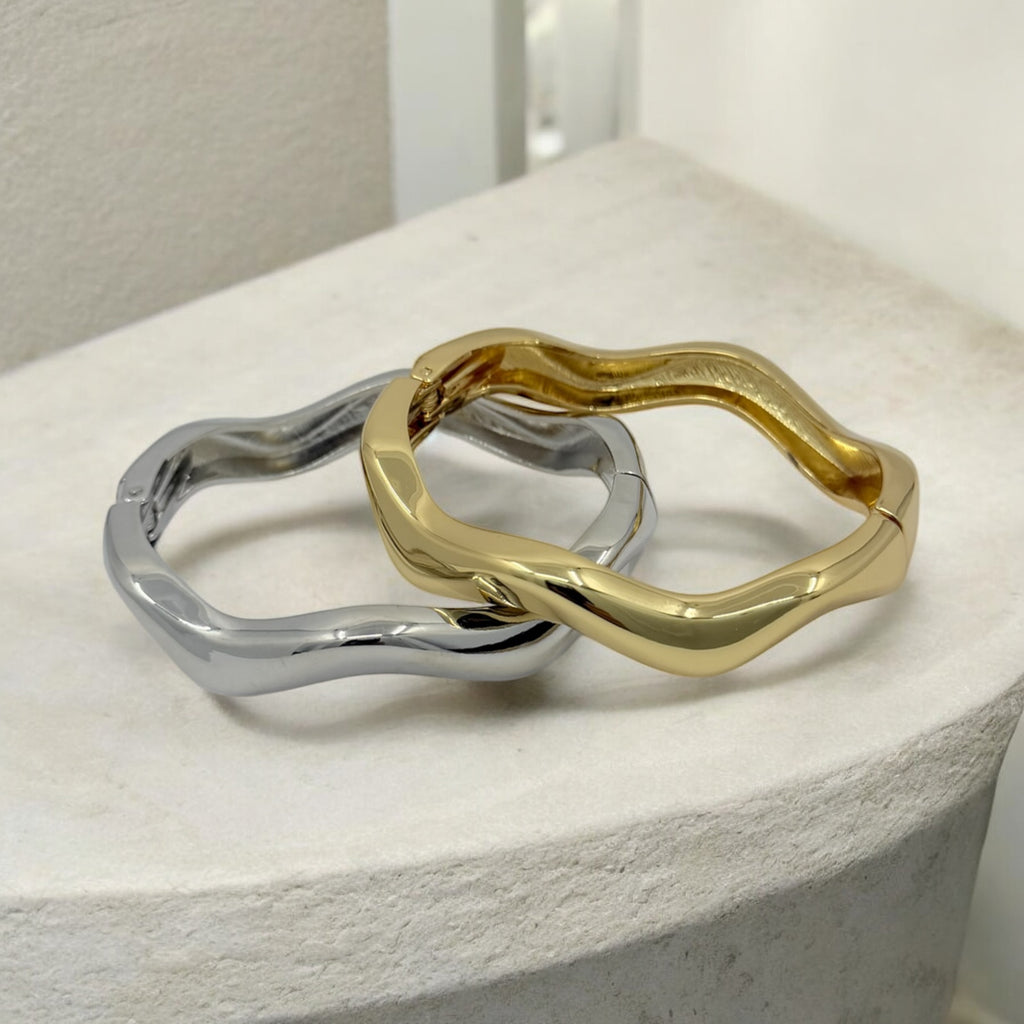 Two gold and silver rings on a white surface