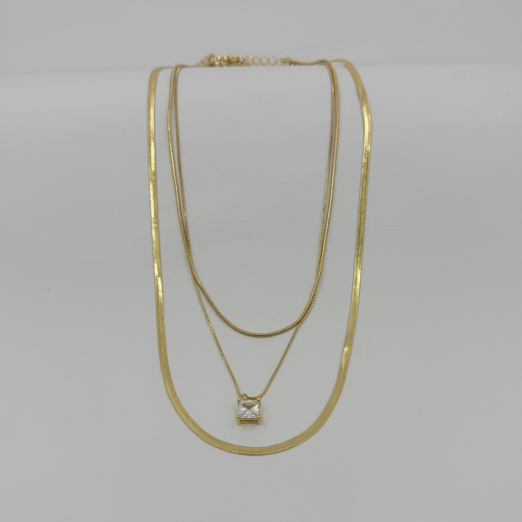 Two gold necklaces on a light gray background