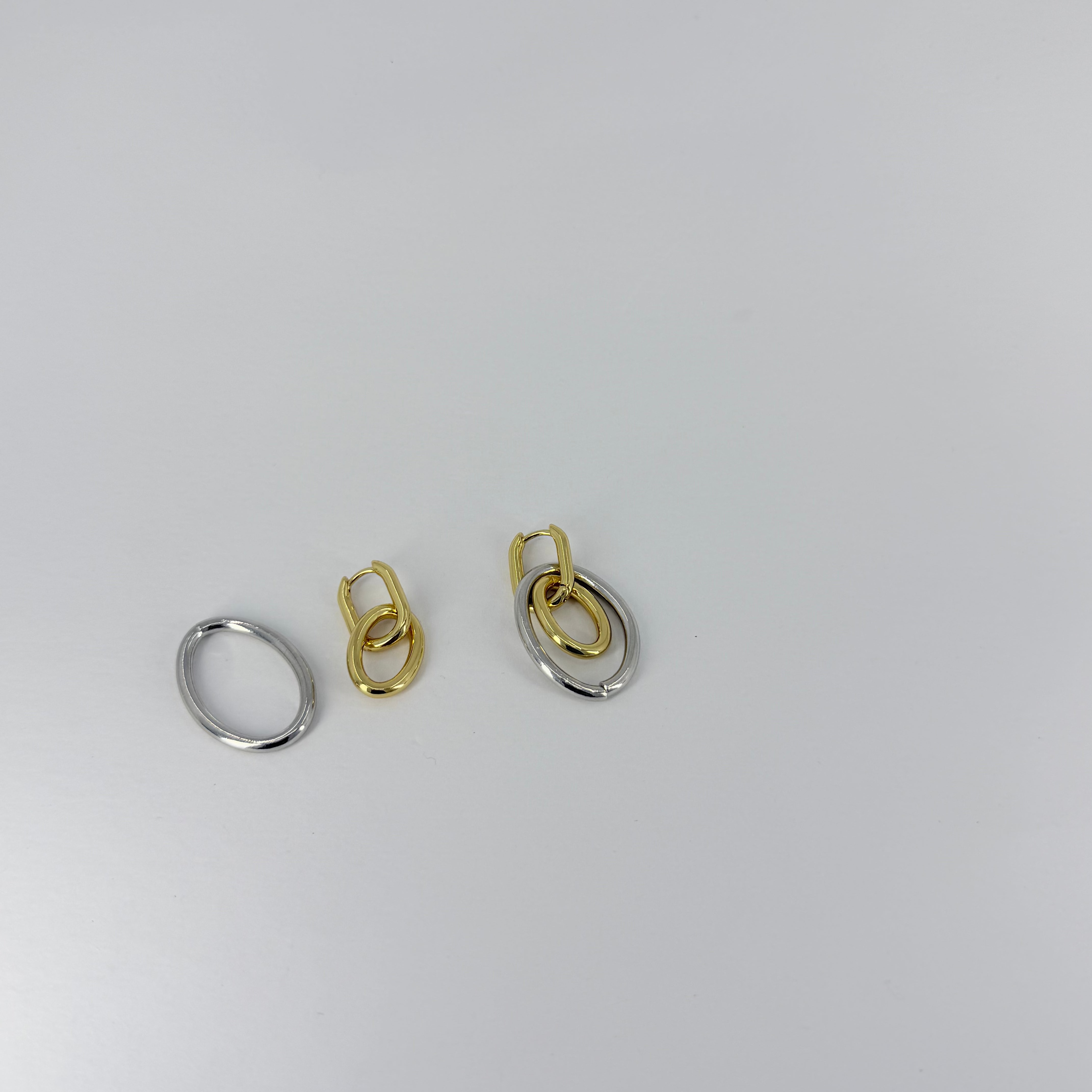 Two pairs of earrings, one gold and one silver, on a white background