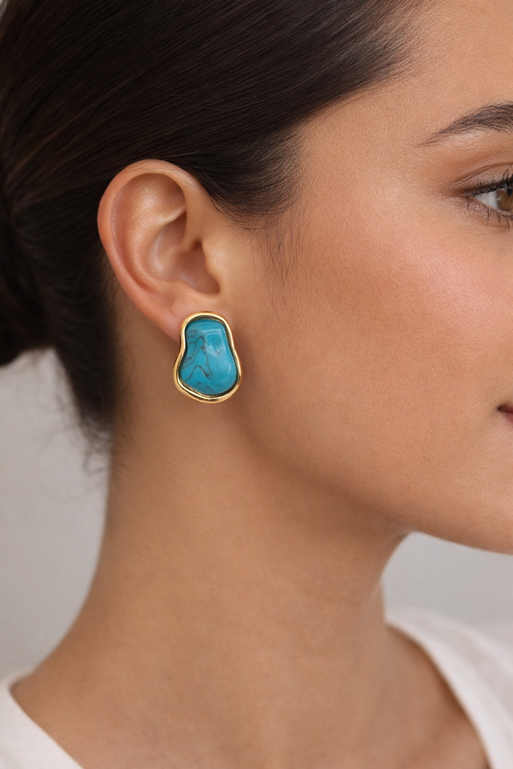 "Turquoise stud earrings worn on ear"